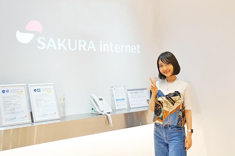 さくらインターネットのロゴ前で写真を撮るちょまどさん