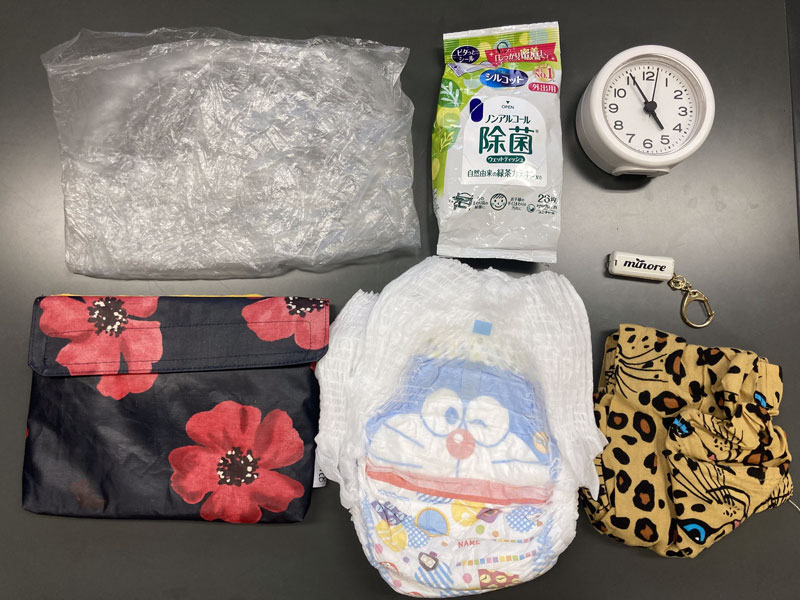 オムツ2つ、子どもの替えのズボン、ビニール袋、ウェットティッシュ、時計、ハーモニカのおもちゃ